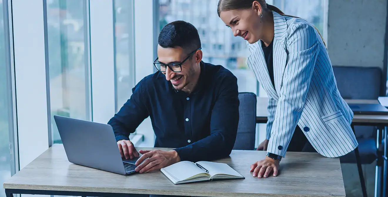 Berater und Kundin besprechen gemeinsam ein Projekt am Laptop – Projektmanagement von SimpleConsultIT